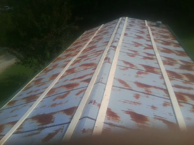 Rusted metal roof panels with new wood purlins before replacement — Storm Damage Roof Repair in Ten Sleep by Roofing Brothers