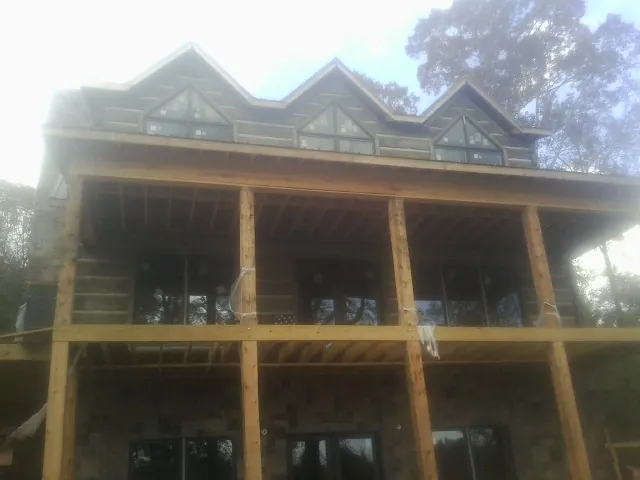 Dormers and porch framing on a large log home under construction — Roof Coating work by our crew in Ten Sleep